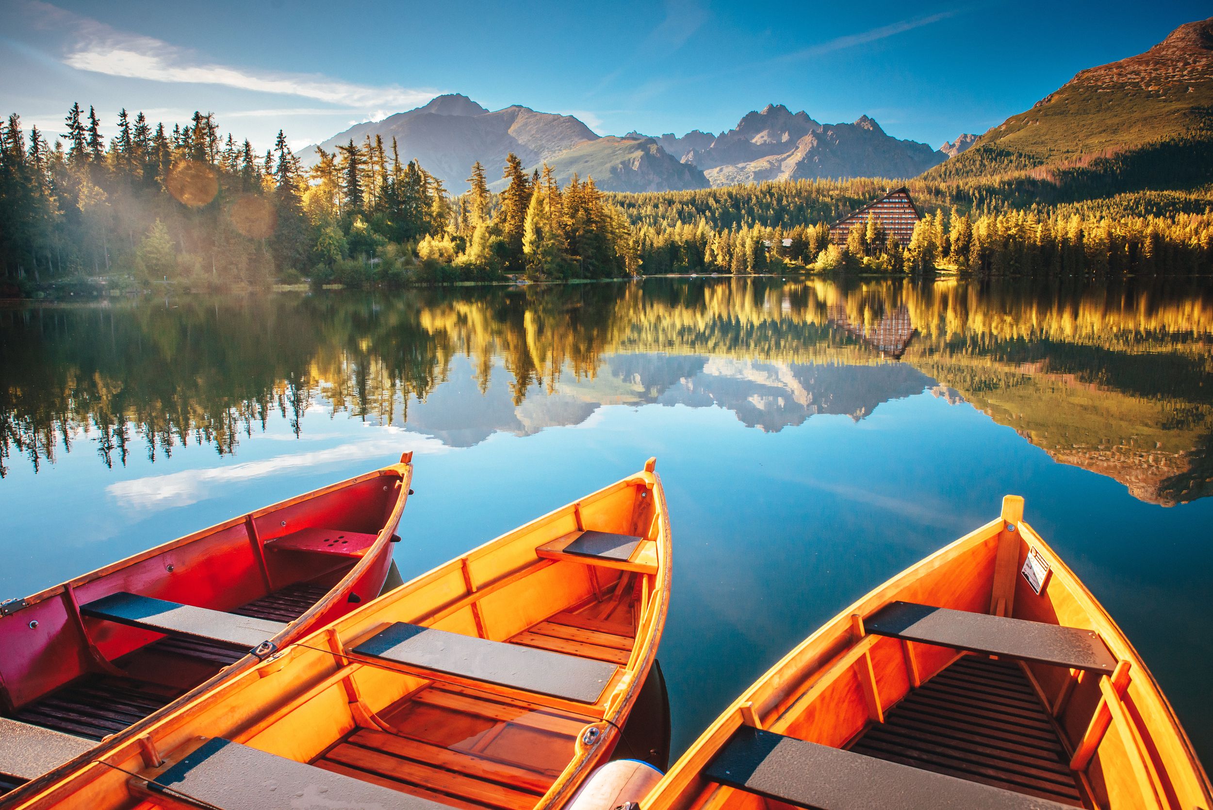 Morning lake Strbske pleso in Tatra mountains. Colorful boats on the w