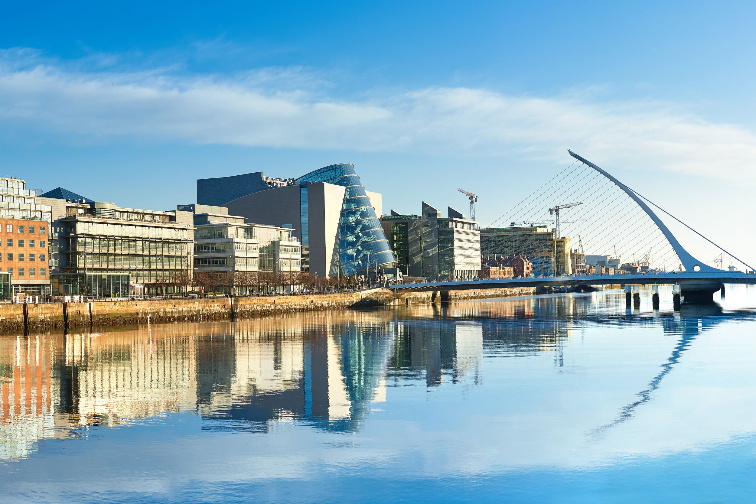 Modern buildings and offices on Liffey river in Dublin on a bright sun