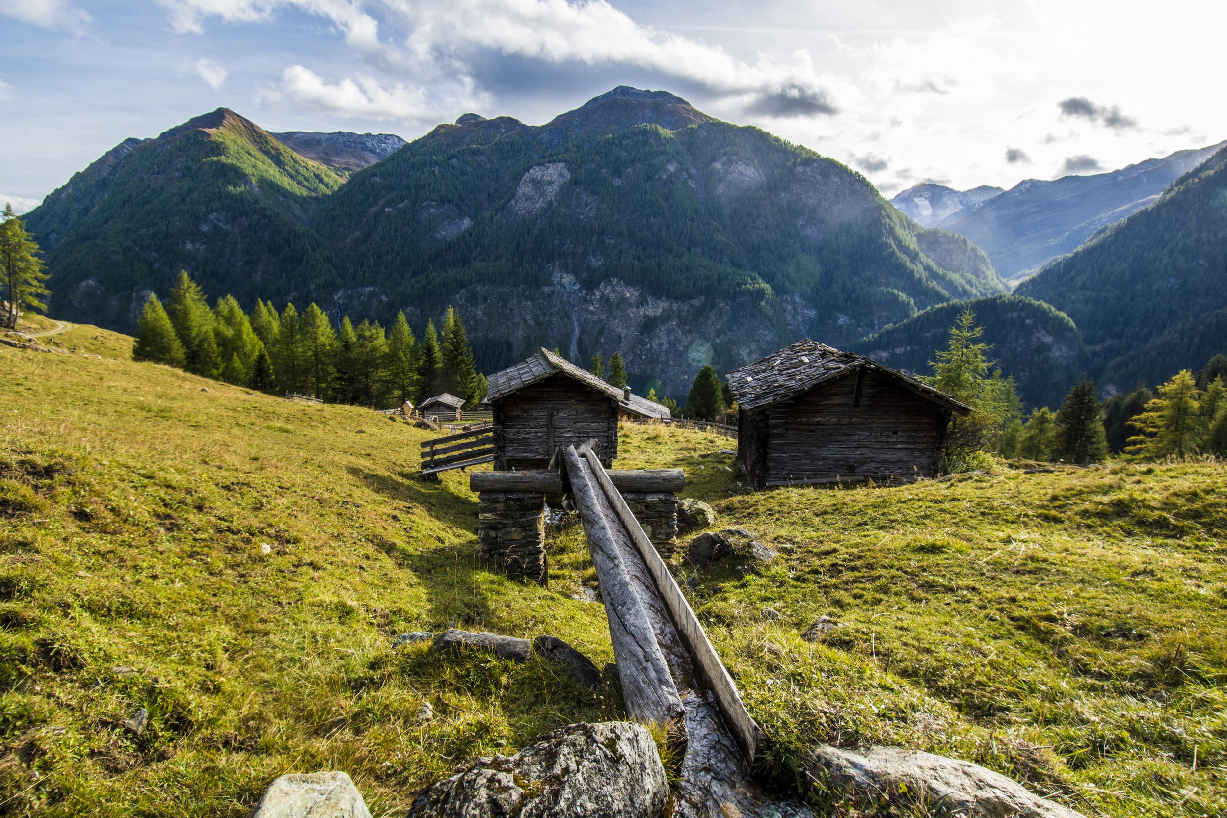Meadow hill surrounded by rocky mountains in Austrian Alps near the Gr