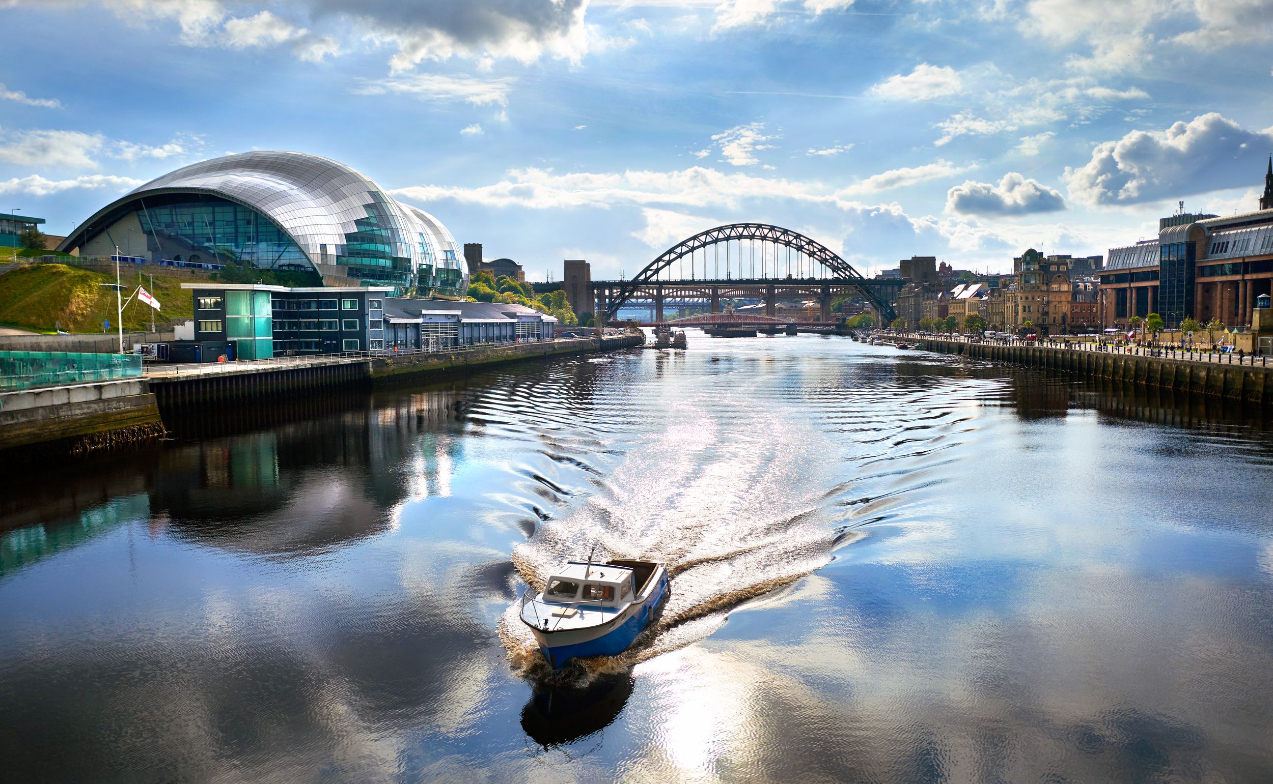 A boat sailing down the River Tyne as it approaches the Millennium Bri