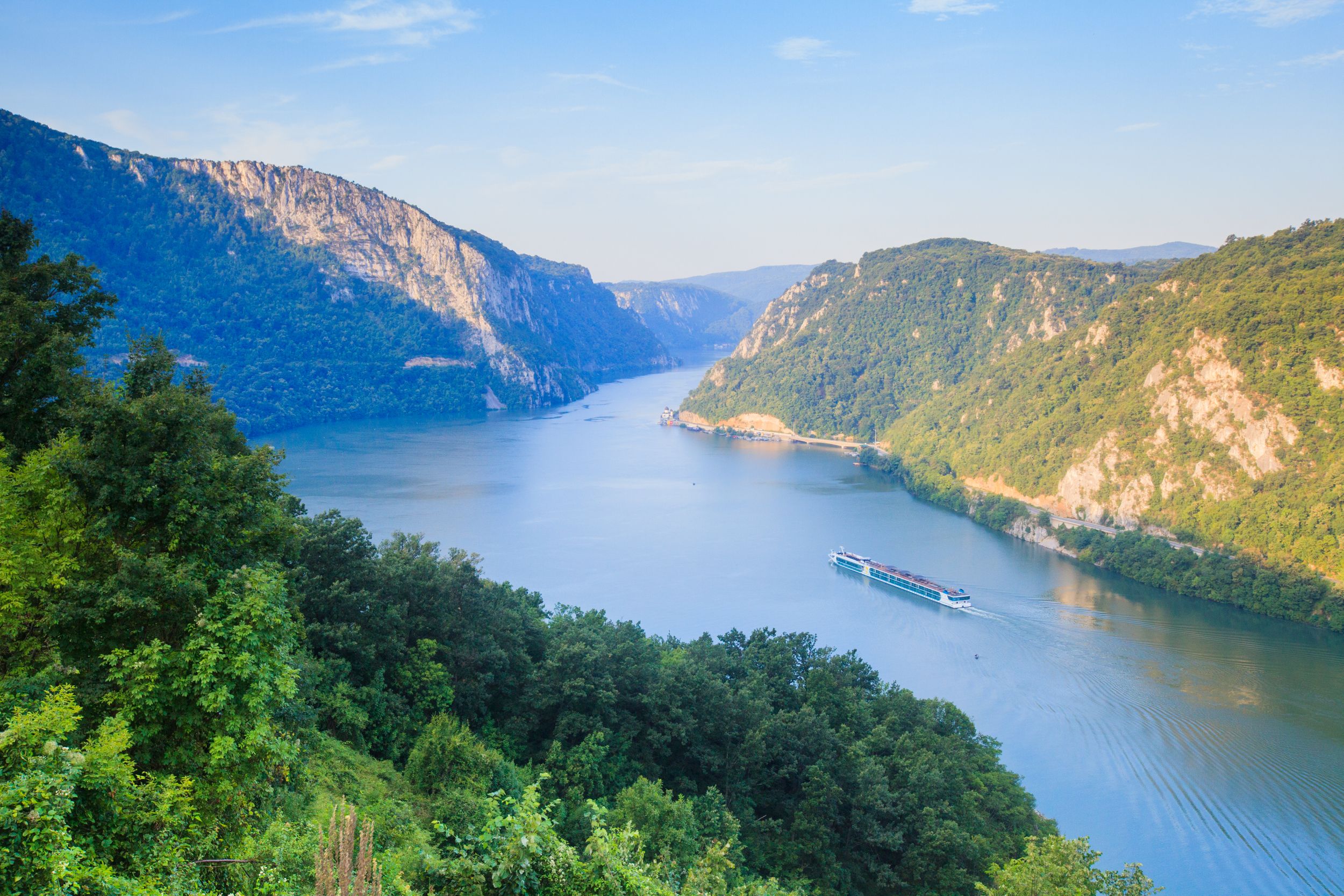 Danube river summer landscape. The cruiser ship passes through the par
