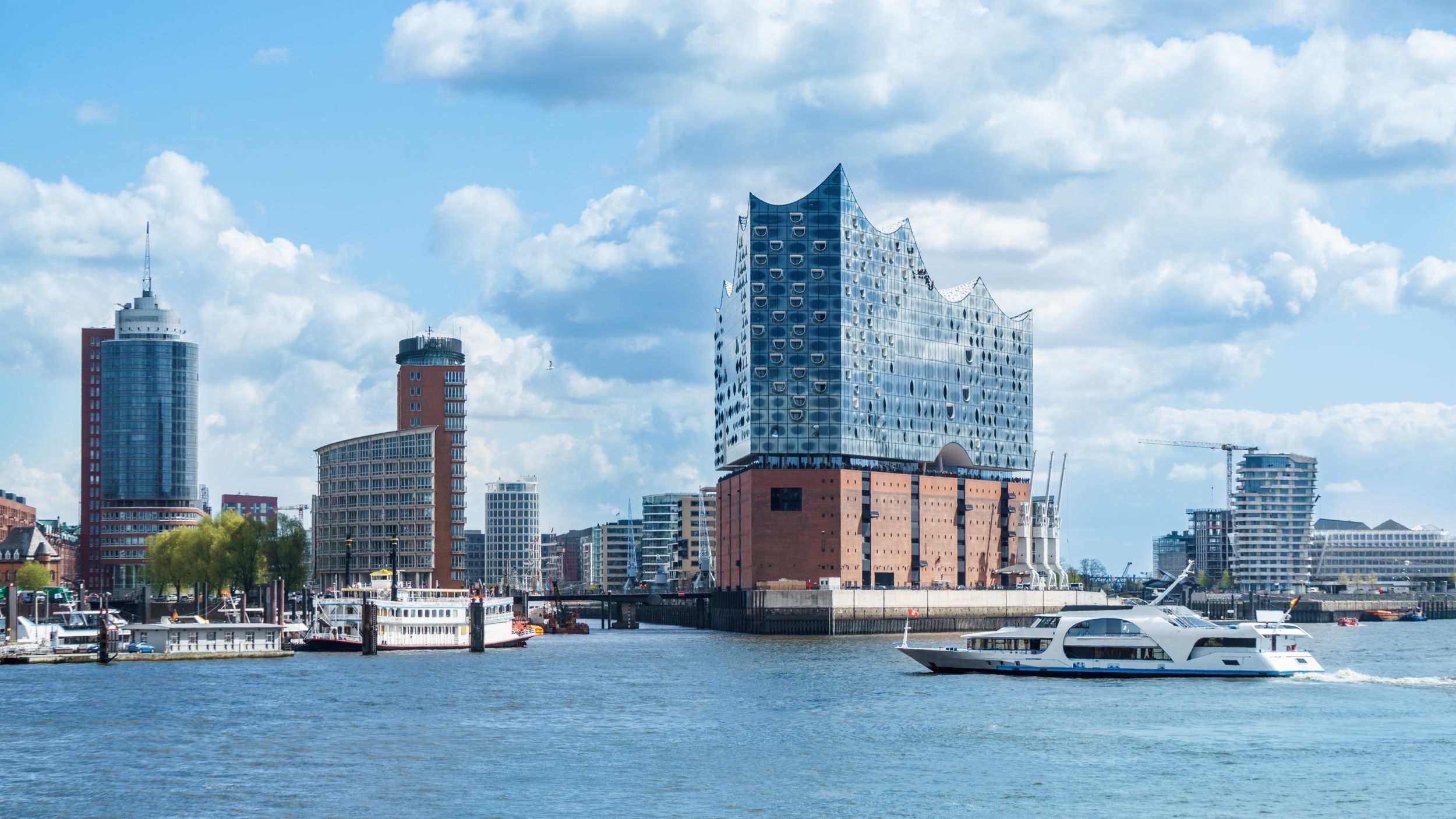 Hamburg, elbphilharmonie and modern buildings with boat to the harbor