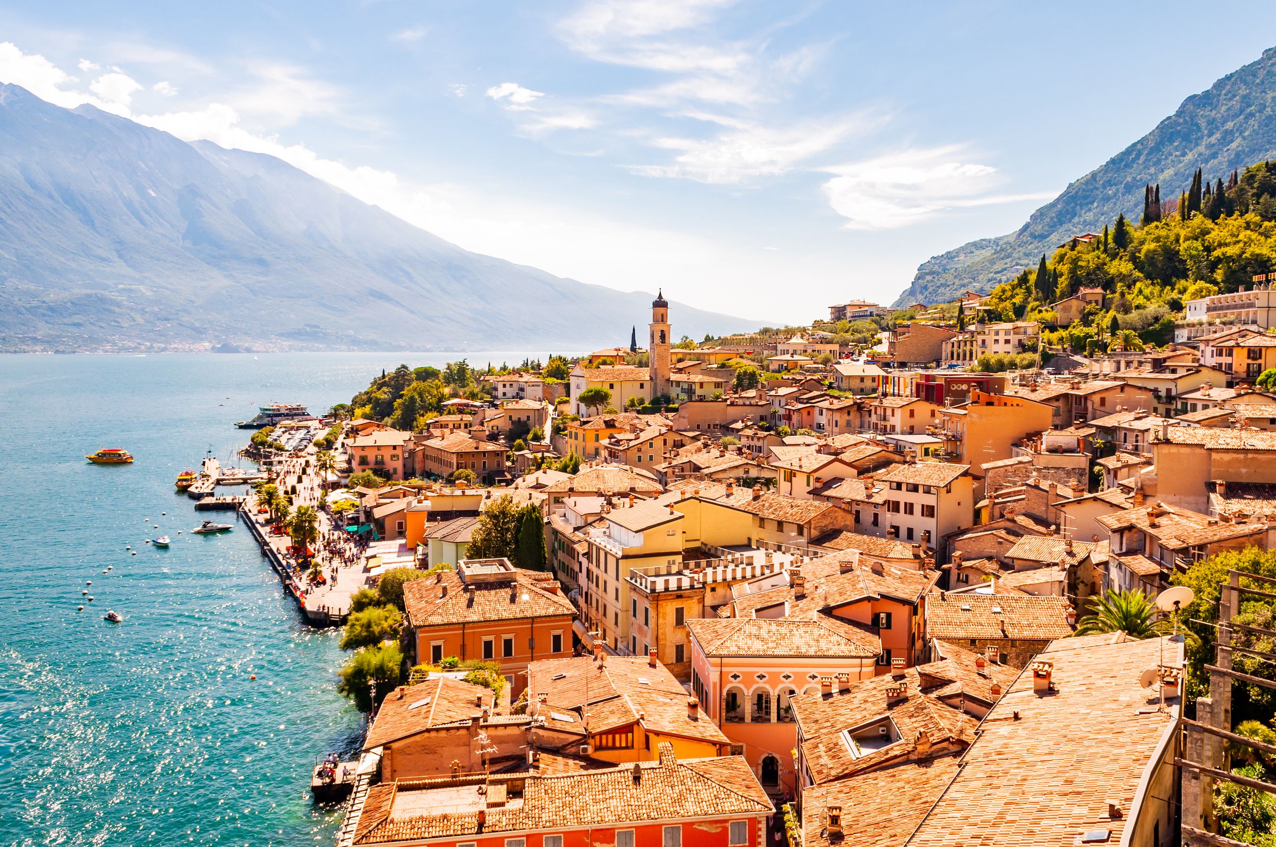 Limone Sul Garda cityscape on the shore of Garda lake surrounded by sc