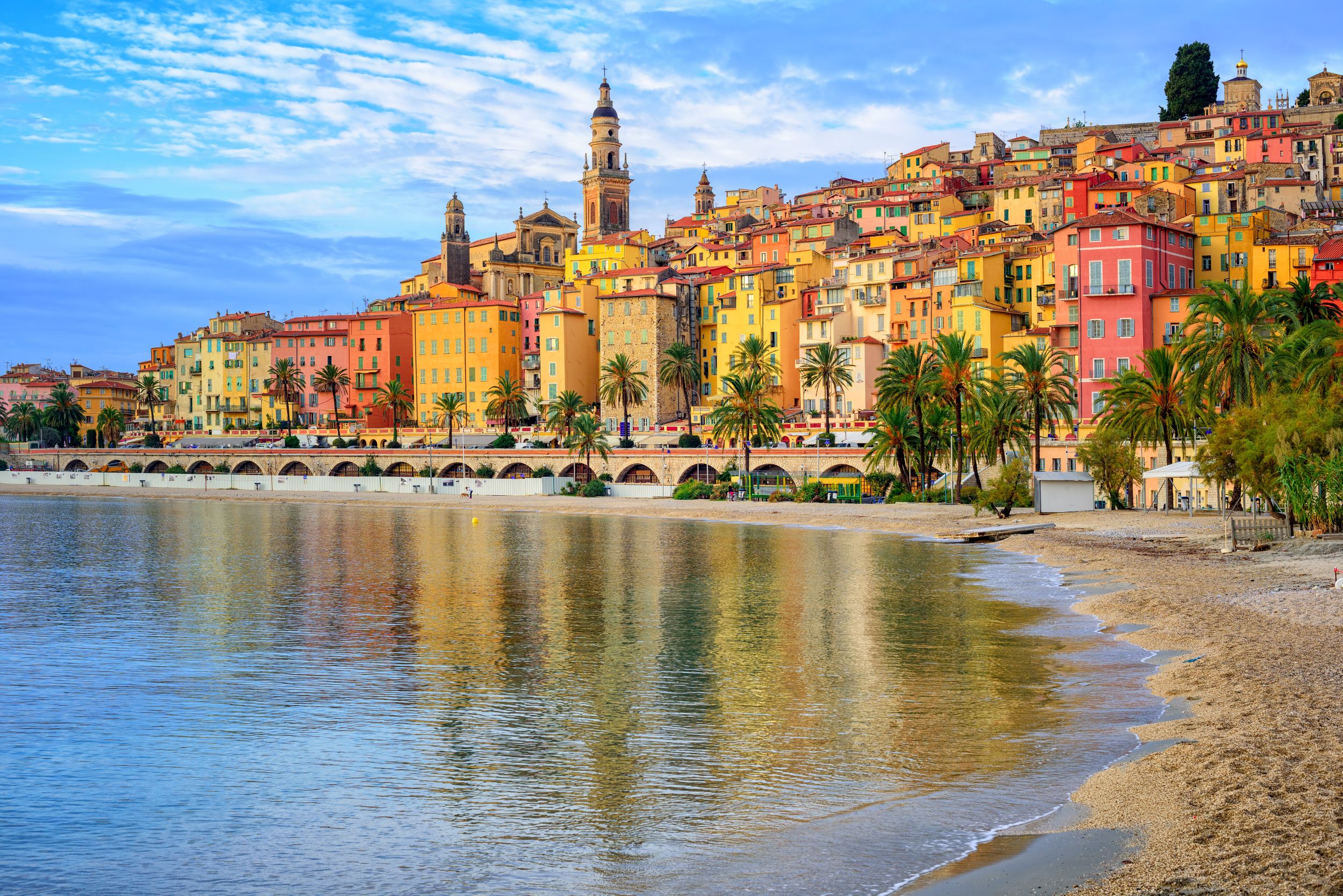 Sand beach beneath the colorful old town Menton on french Riviera, Fra