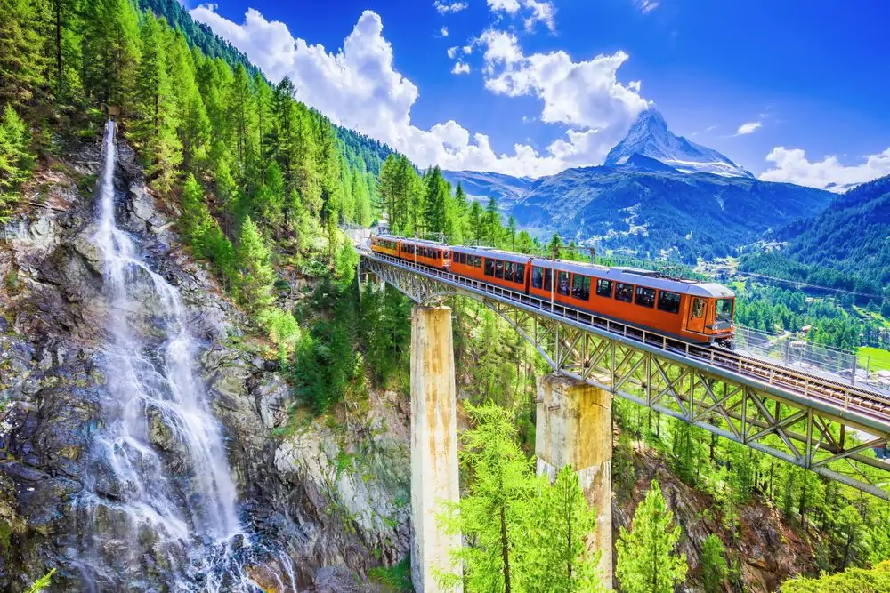 Zermatt, Switzerland. Gornergrat tourist train with waterfall, bridge 